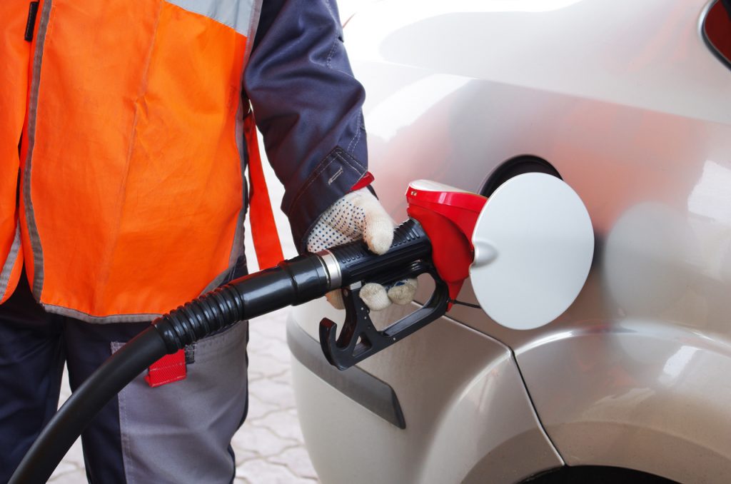 Technician fueling up a car at station