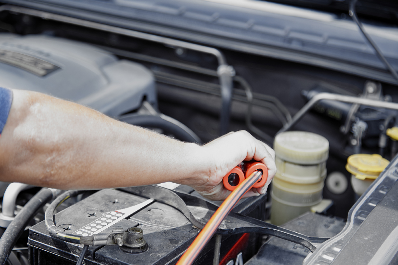 Technician jump starting a car