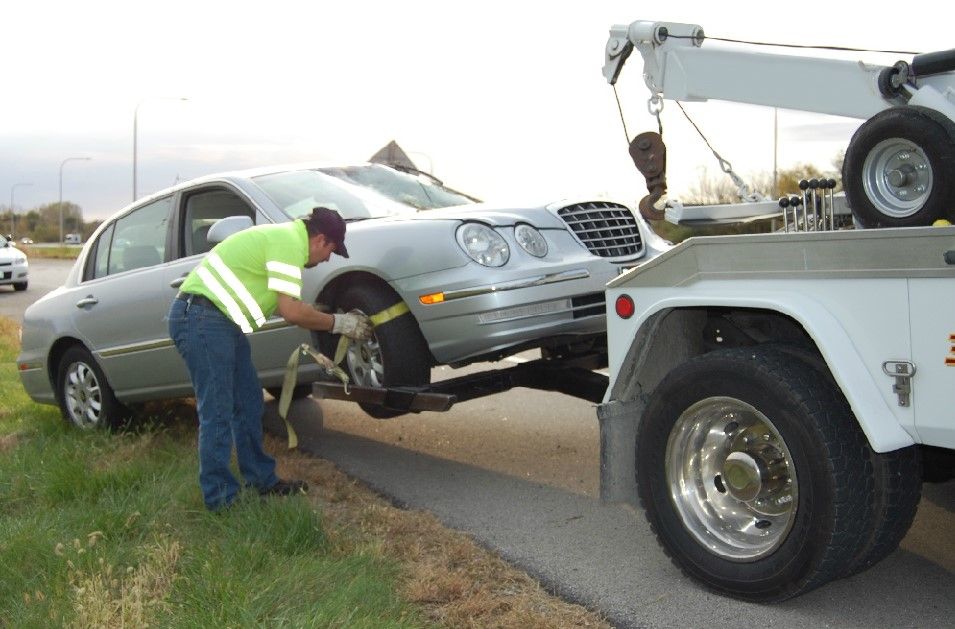 Wheel Lift Tow Truck Hauling A Car Out Of A Ditch