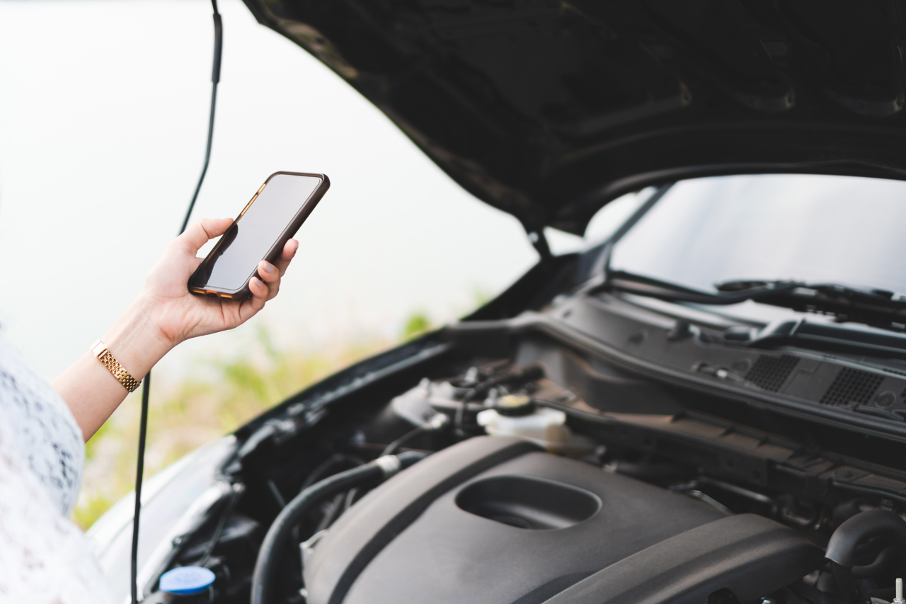 Woman calling a towing service on her cell phone